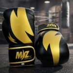 Mizlet Gold Elite black and gold boxing gloves in a boxing gym